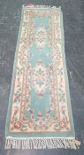 Chinese green ground runner with two central foliate motifs, 206cm x 68cm