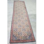 Large cream ground Eastern runner with repeating pattern, in blues, pinks, yellows, with red