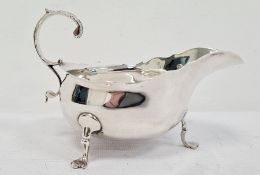 Victorian silver sauce-boat having everted rim, foliate decorated free C-scroll handle, on three