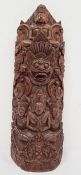 Indian carved hardwood obelisk of deities and grotesque mask, 32cm high