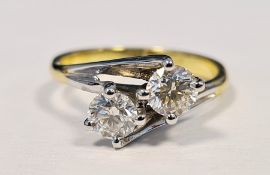 Gold coloured and white metal diamond two-stone ring, of crossover design set with two round