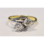 Gold coloured and white metal diamond two-stone ring, of crossover design set with two round