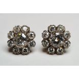 Pair of white metal diamond flowerhead cluster stud earrings, each set with a central brilliant cut