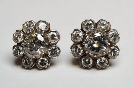 Pair of white metal diamond flowerhead cluster stud earrings, each set with a central brilliant cut