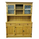 20th century oak dresser with moulded pediment above two lead glazed doors, central open shelves,