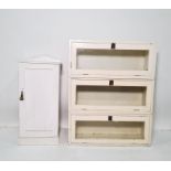 White painted sectional bookcase of three parts and a white painted pot cupboard (2)