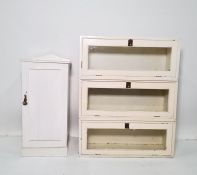 White painted sectional bookcase of three parts and a white painted pot cupboard (2)