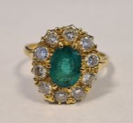 18ct yellow gold emerald and diamond cluster ring, the central oval mixed-cut emerald (estimated