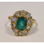 18ct yellow gold emerald and diamond cluster ring, the central oval mixed-cut emerald (estimated