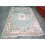 Chinese green ground rug with central cream ground motif, 273cm x 181cm