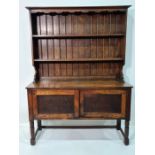 Early 20th century oak dresser, the ogee moulded pediment above two shelves, base of two cupboard