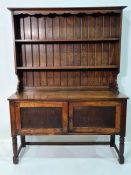 Early 20th century oak dresser, the ogee moulded pediment above two shelves, base of two cupboard