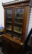 Edwardian walnut bookcase with two glazed doors enclosing shelves, above two drawers and two