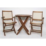 Teak folding garden table and a pair of teak and plastic backed and seated folding chairs, with a
