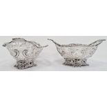Pair of Victorian silver foliate decorated and pierced bonbon dishes raised upon four pierced