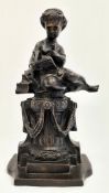 Late 19th/early 20th century bronze figure of lady seated on pillar, reading a book