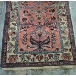Persian rug, salmon ground decorated in blues, creams and reds, stepped border, 178cm x 104cm