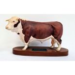 Beswick tinted bisque porcelain 'Connoisseur' model of a Hereford bull, on polished wooden plinth