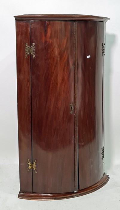 19th century mahogany bowfront wall-hanging corner display cabinet, the two doors opening to
