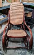 After design by Thonet, a bentwood rocking chair with cane back and seat