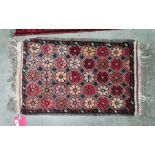 Small Eastern rug, salmon ground, flowerhead motif, 76cm x 41cm