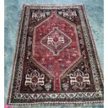 Persian rug, the central medallion with hooked motif, red ground field with flowerhead decoration,
