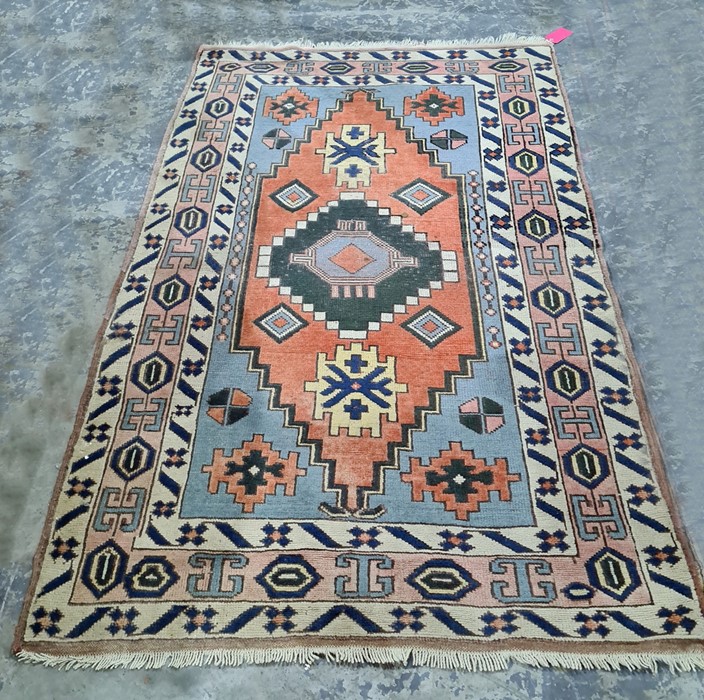 Persian rug with central medallion, stepped border, the whole in creams, blues, peaches and yellows,