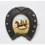 Late Victorian silver brooch in the form of a horseshoe, the centre enamel decorated with horse