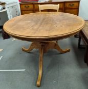 Circular pine breakfast table on turned pedestal to three cabriole legs, 121cm diameter