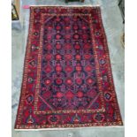 Eastern rug, blue ground with red hooked motifs, canted corners to the central field, wide margin
