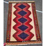 Eastern rug, with five blue ground diamond shaped medallions, in pinks, blues, cream and green,