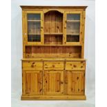 20th century pine dresser with moulded pediment above open shelves flanked by glazed doors, the base