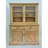 Late 19th century pine dresser with moulded pediment above two glazed doors enclosing shelves, faced