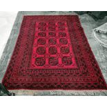 Red ground Persian rug, the central field with 18 elephant's foot guls, on a multi-stepped border,