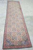 Large cream ground Eastern runner with repeating pattern, in blues, pinks, yellows, with red