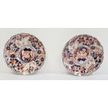 Pair of Japanese Imari circular dishes, each painted with scrolling foliage, bamboo and rockwork,