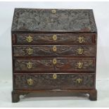 Victorian carved oak bureau, the fall heavily carved with green man decoration, the fall graduated