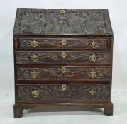 Victorian carved oak bureau, the fall heavily carved with green man decoration, the fall graduated