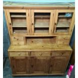 Late 19th/early 20th century pine dresser with ogee moulded pediment above three glazed doors