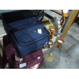 Two suitcases, assorted textiles and a floor-standing candle holder