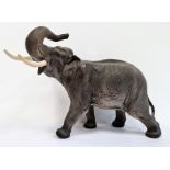 Beswick tinted bisque porcelain model of elephant with trunk raised, 41cm wide overall