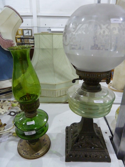 Paraffin lamp with a clear glass bowl, supported on a decorative metal single-column base with a