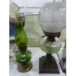 Paraffin lamp with a clear glass bowl, supported on a decorative metal single-column base with a