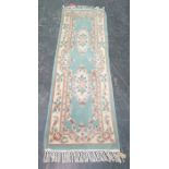 Chinese green ground runner with two central foliate motifs, 206cm x 68cm