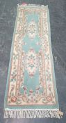 Chinese green ground runner with two central foliate motifs, 206cm x 68cm