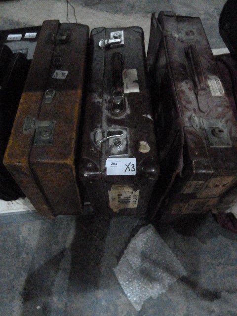 Two vintage leather suitcases, one with various travel labels, another suitcase and two boxes of