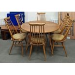Light elm Ercol drop-leaf table raised on beech supports and a set of six Ercol light elm seated and