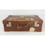 Vintage leather suitcase bearing luggage labels