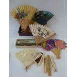 A quantity of wooden Oriental souvenir fans and modern plastic fans