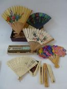 A quantity of wooden Oriental souvenir fans and modern plastic fans